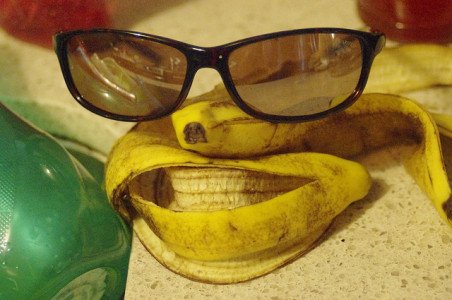 A banana peel made to resemble a face, with sunglasses added for eyes.