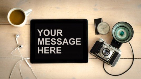 A camera with an iPad with the text "Your Message Here"
