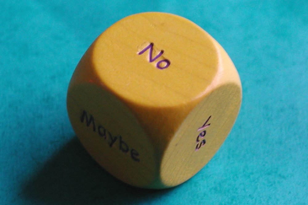 Image: six-sided die showing faces labeled Yes, No, and Maybe