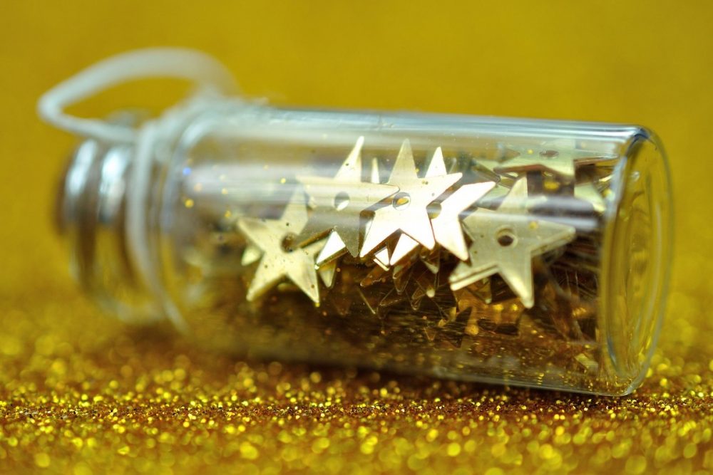 Image: a small bottle full of gold metal stars