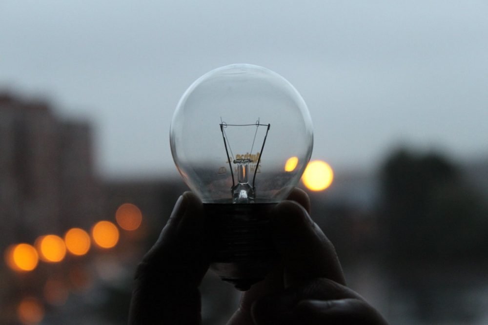 Image: hand holding an unlit lightbulb