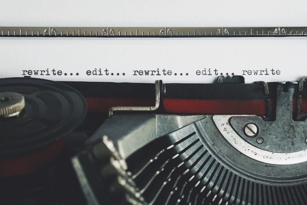 Image: Typewriter typing the words "rewrite… edit… rewrite… edit… rewrite"