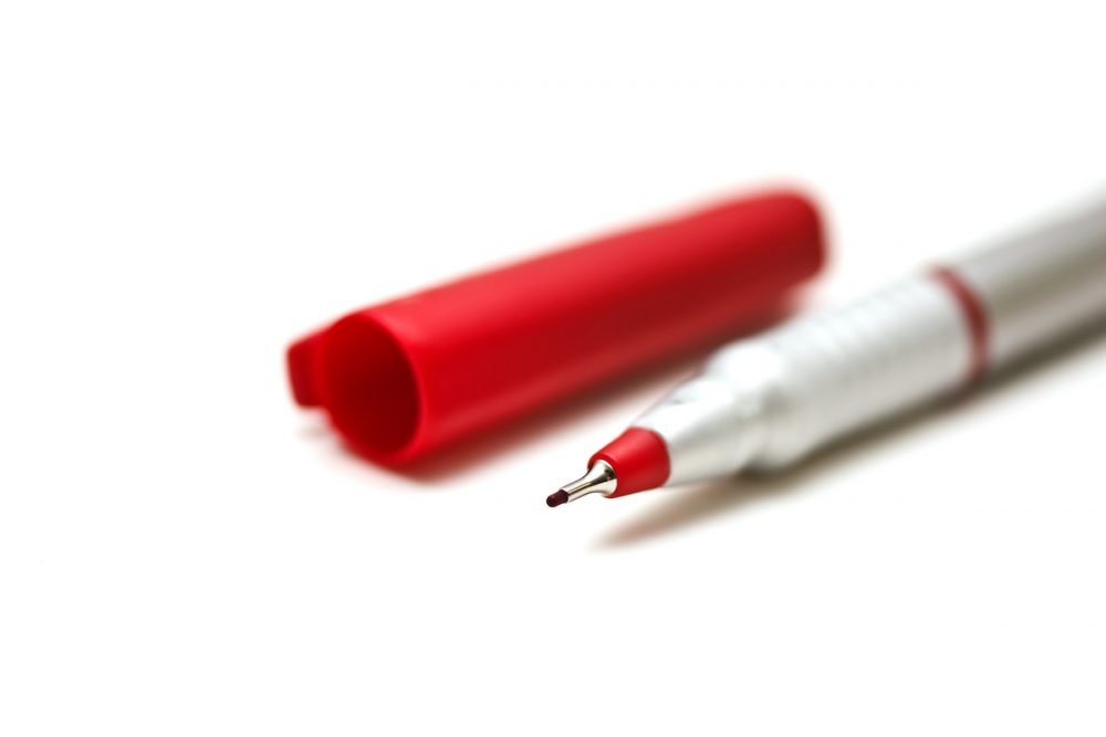Image: fine-point red marker on white background.