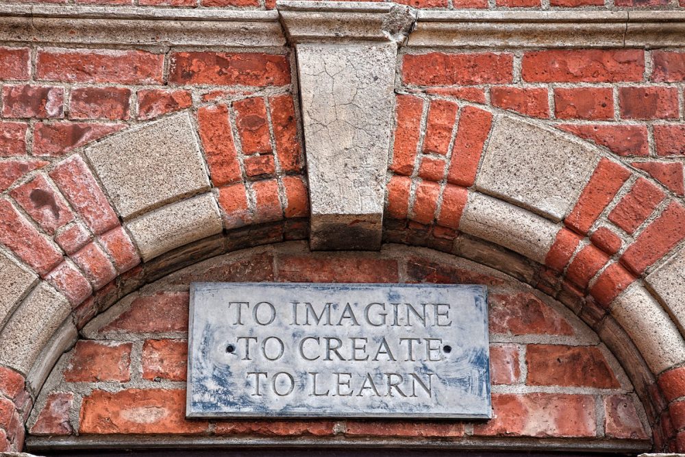 Image: a plaque inscribed with the words "To imagine, to create, to learn".