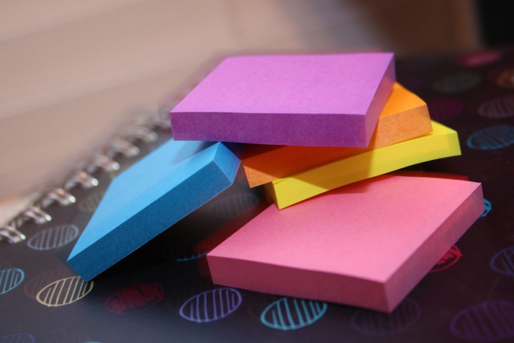 Image: a stack of multi-colored Post-It notes