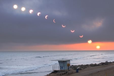 Image: composite photo of an eclipsing sun setting over the Pacific Ocean.