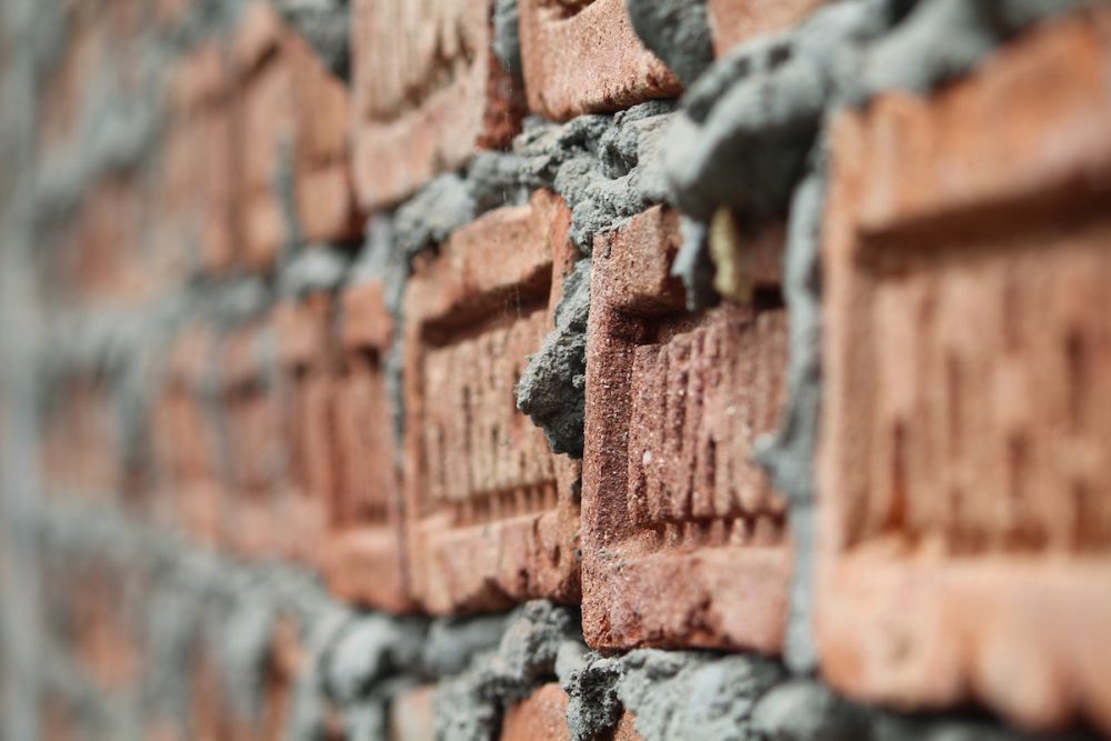 Image: close-up photo of mortar between bricks in a wall.