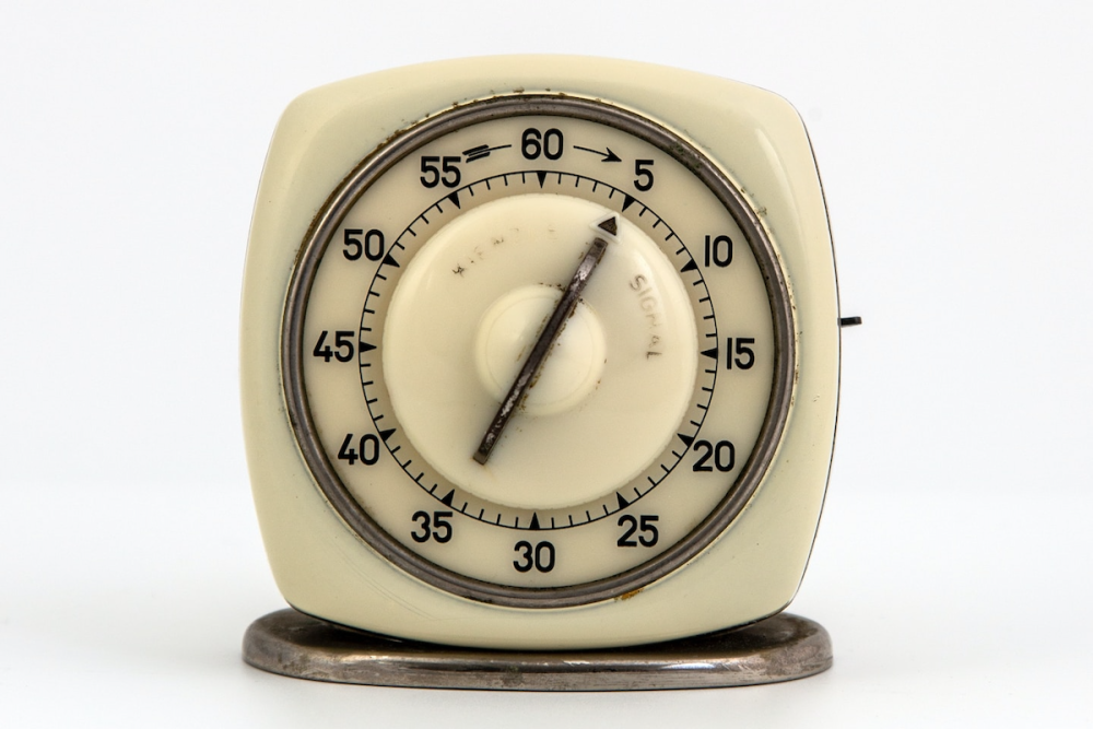 Image: an antique timer with the dial set to the 5 mark.