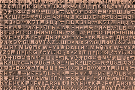 Image: an artwork comprised of many rows of three-dimensional characters from numerous languages mounted next to one another in random order on a backing board.